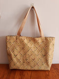 Beige tote bag on a wooden surface with a plain background