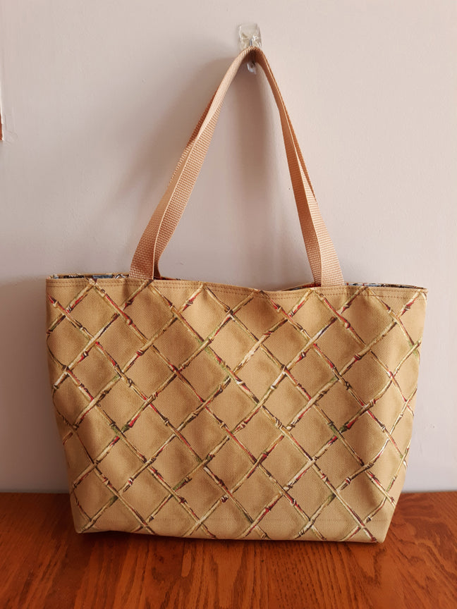 Beige tote bag on a wooden surface with a plain background